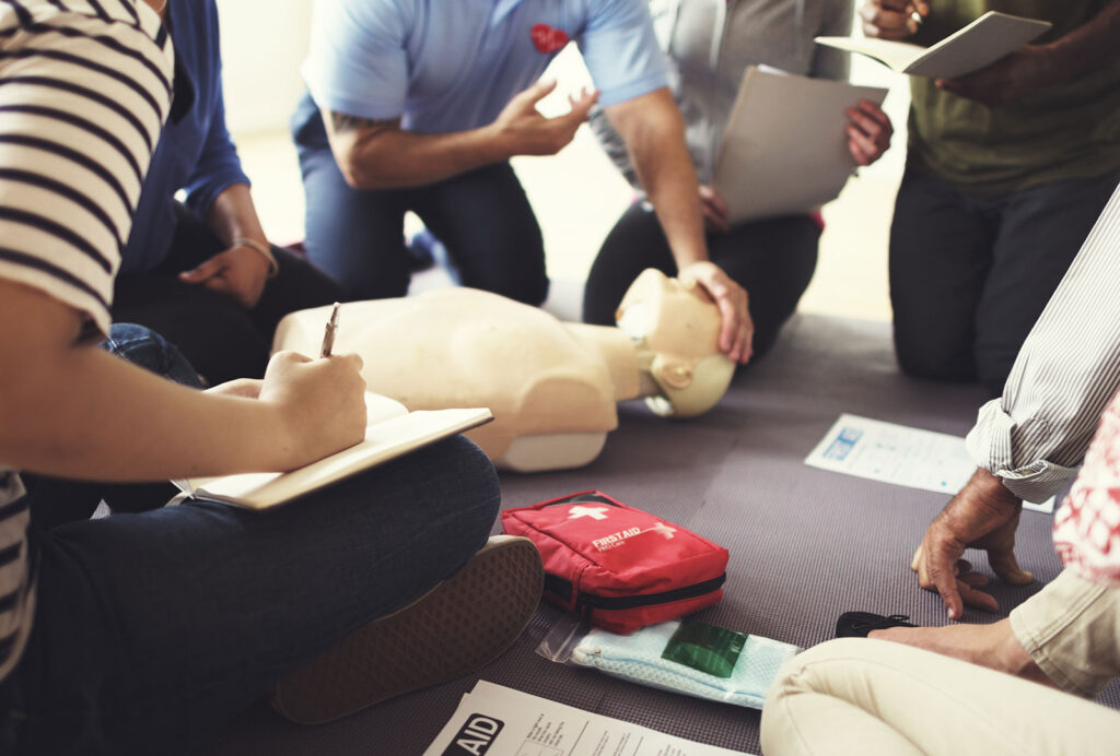 Residents practicing CPR techniques during a first aid training session